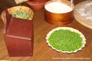 After the tart is filled with the boiled and drained peas for the receipt (recipe) Green Peas Tart season them with salt. My salt box is to the left of the picture.